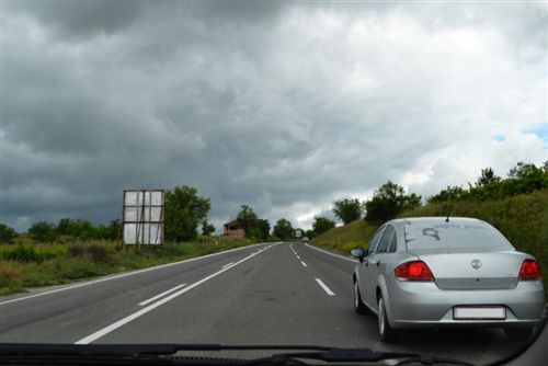 Кога се движи на коловоз за сообраќај на возила во двете насоки на кој постојат три сообраќајни ленти (како на сликата), возачот со возилото: