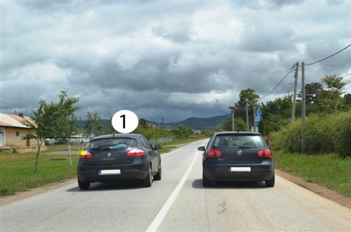 Shoferi i automjetit të shënuar me numër 1, në këtë pjesë të rrugës, të dedikuar për komunikacion të automjeteve në të dy anët (si në fotografinë), bën parakalim: