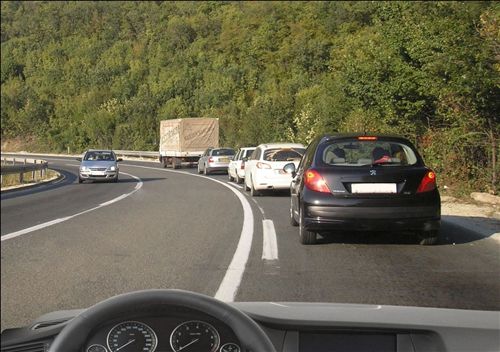 На дел од патот со три сообраќајни ленти наменет за сообраќај на возила во двете насоки, кога со возилото се движите зад колона на возила, како на сликата: