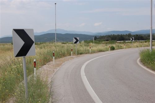 Shenjat e komunikacionit të paraqitura në fotografi , të vendosura në vend të mpreht dhe kthesë jo të dukshme të rrugës, tregojnë: