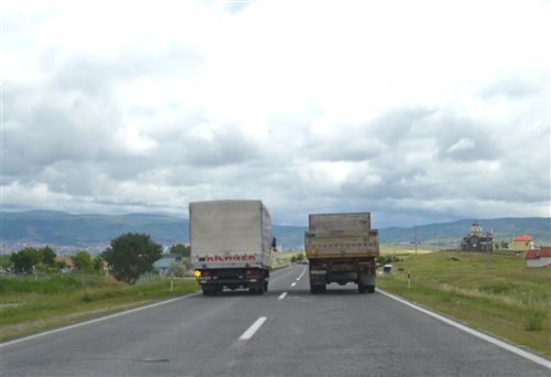 Shoferi i automjetit transportues të mallrave, i cili qarkullon nëpër korsinë e majtë të komunikacionit në rrugë jashtë vendbanimit (si në fotografinë):